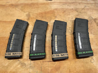 Thumbnail for Four black AR rifle magazine bands with '5.56 NATO' and '300 Blackout' text on a wooden surface.